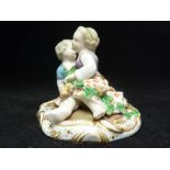 A Meissen porcelain figure group, of two children seated with grape vine garland, on an oval base