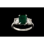 AN EMERALD AND DIAMOND THREE STONE RING, with emerald of approx. 2.75ct, diamonds of approx. 1.