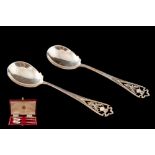 A PAIR OF VICTORIAN SILVER PRESERVE SPOONS, with thistle motif, cased, Edinburgh 1896