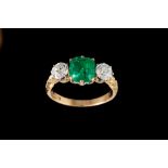 AN EMERALD AND DIAMOND THREE STONE RING, with one cushion cut emerald of 2.
