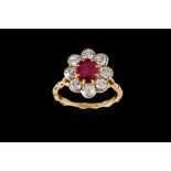 A RUBY AND DIAMOND OVAL DAISY CLUSTER RING, one oval cut ruby of approx 1.