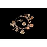 A 9CT GOLD CHARM BRACELET,