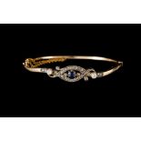 AN EDWARDIAN SAPPHIRE AND DIAMOND HINGED BANGLE, boxed, with one cushion cut sapphire of approx 0.