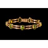 AN EDWARDIAN PERIDOT LINK BRACELET, in 15ct rose gold.