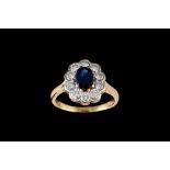 A SAPPHIRE AND DIAMOND OVAL CLUSTER RING, one oval cut sapphire of approx 1.