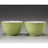 A pair of Chinese lime-green-enamelled cups