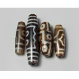 A group of four Tibetan dzi beads