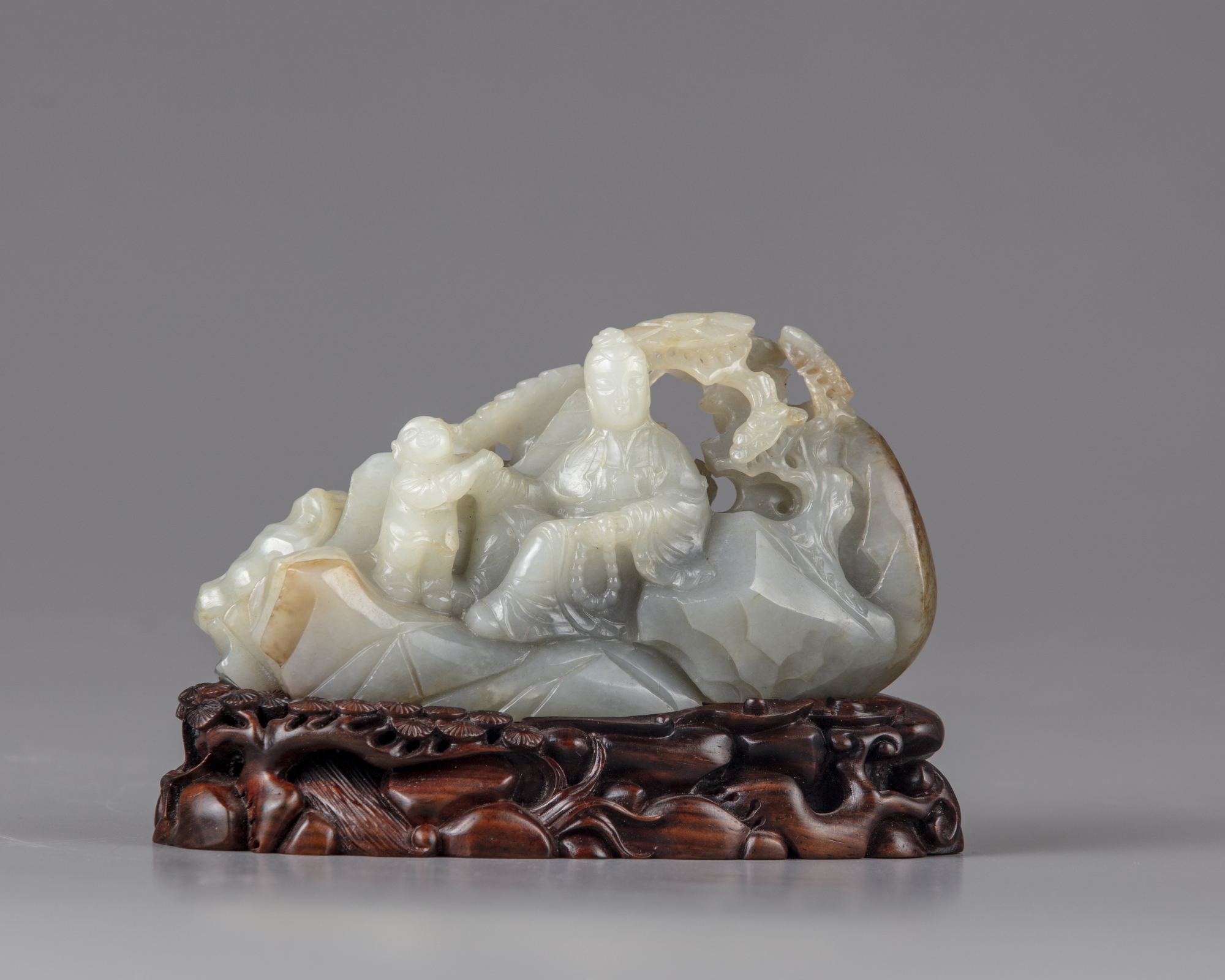 A celadon jade carving of a lady and a boy