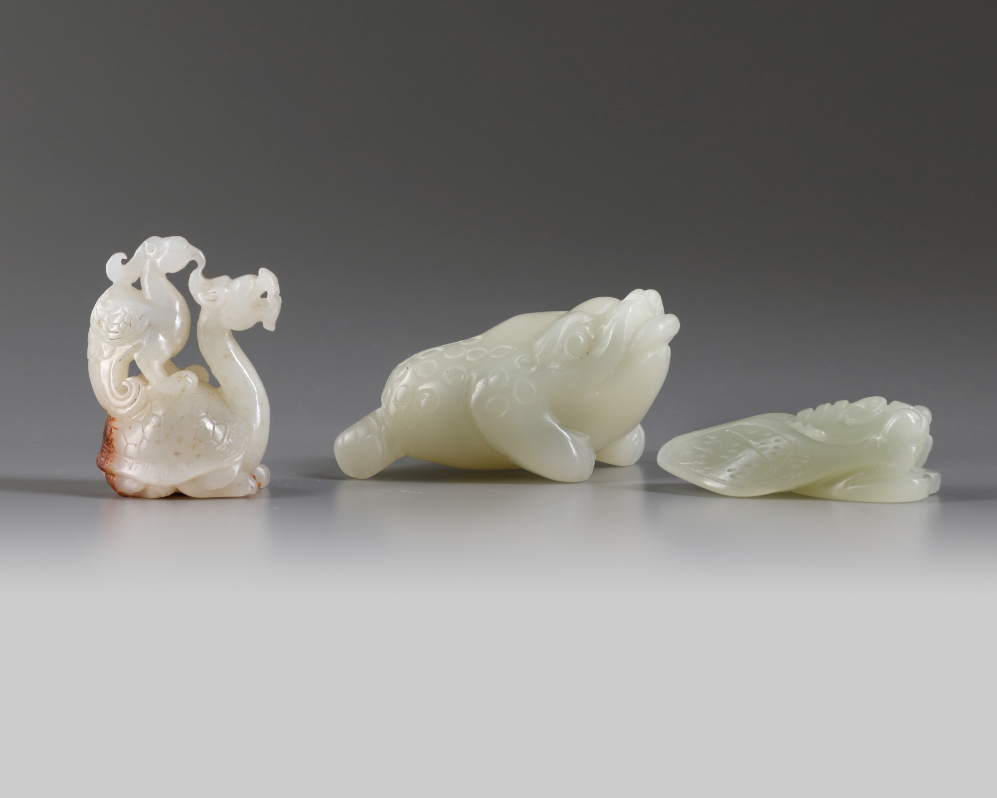 A group of Chinese white and pale celadon jade mythical beast carvings