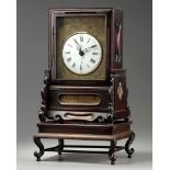 A Chinese gilt bronze table clock in a hongmu case and stand