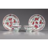 A pair of famille rose cups and saucers