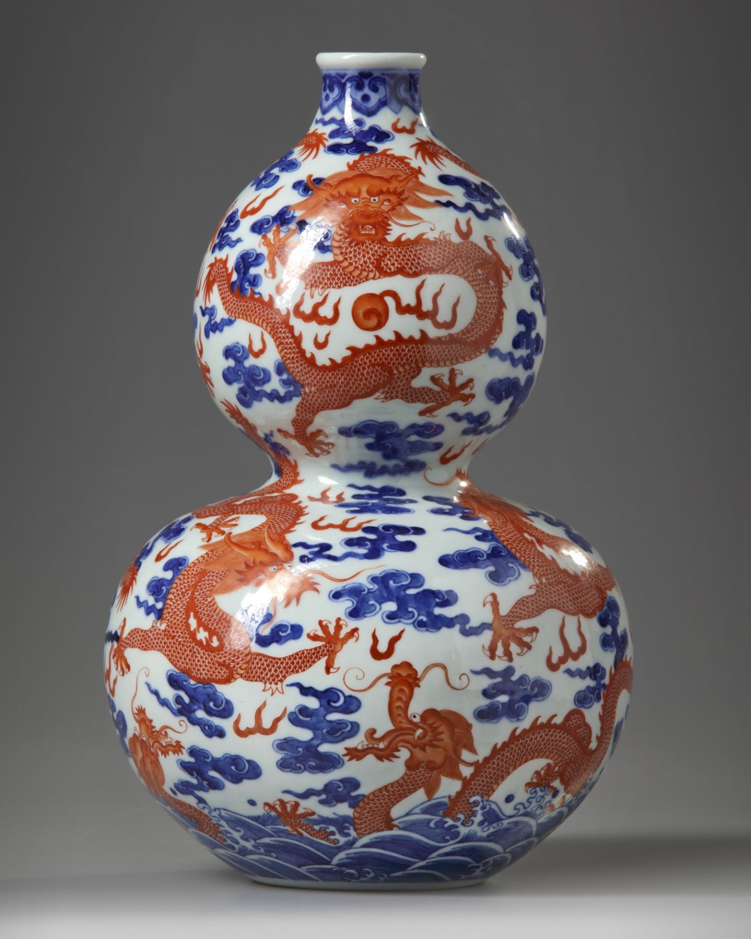 A Chinese iron-red-decorated blue and white 'dragon' double gourd vase