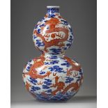 A Chinese iron-red-decorated blue and white 'dragon' double gourd vase