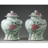 A pair of Chinese famille rose 'floral' vases and covers