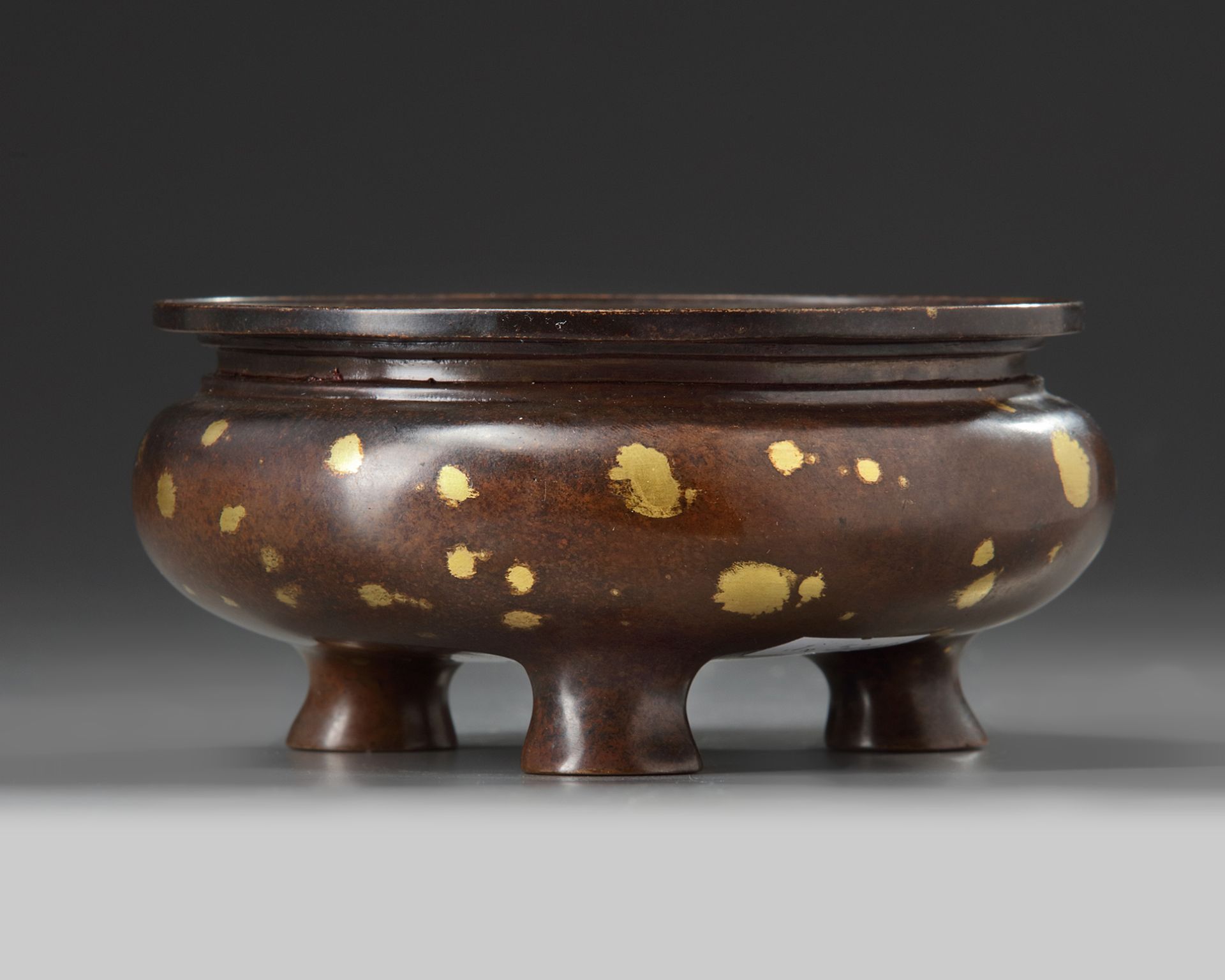 A Chinese gilt splashed bronze tripod censer