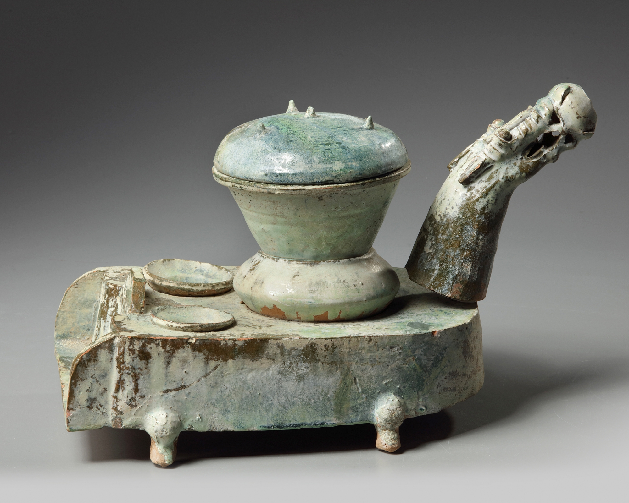 A Chinese green-glazed pottery stove with a dragon chimney