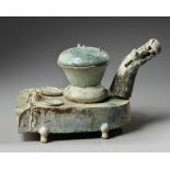 A Chinese green-glazed pottery stove with a dragon chimney