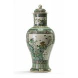 A Chinese famille verte biscuit 'butterflies and flowers' vase and cover