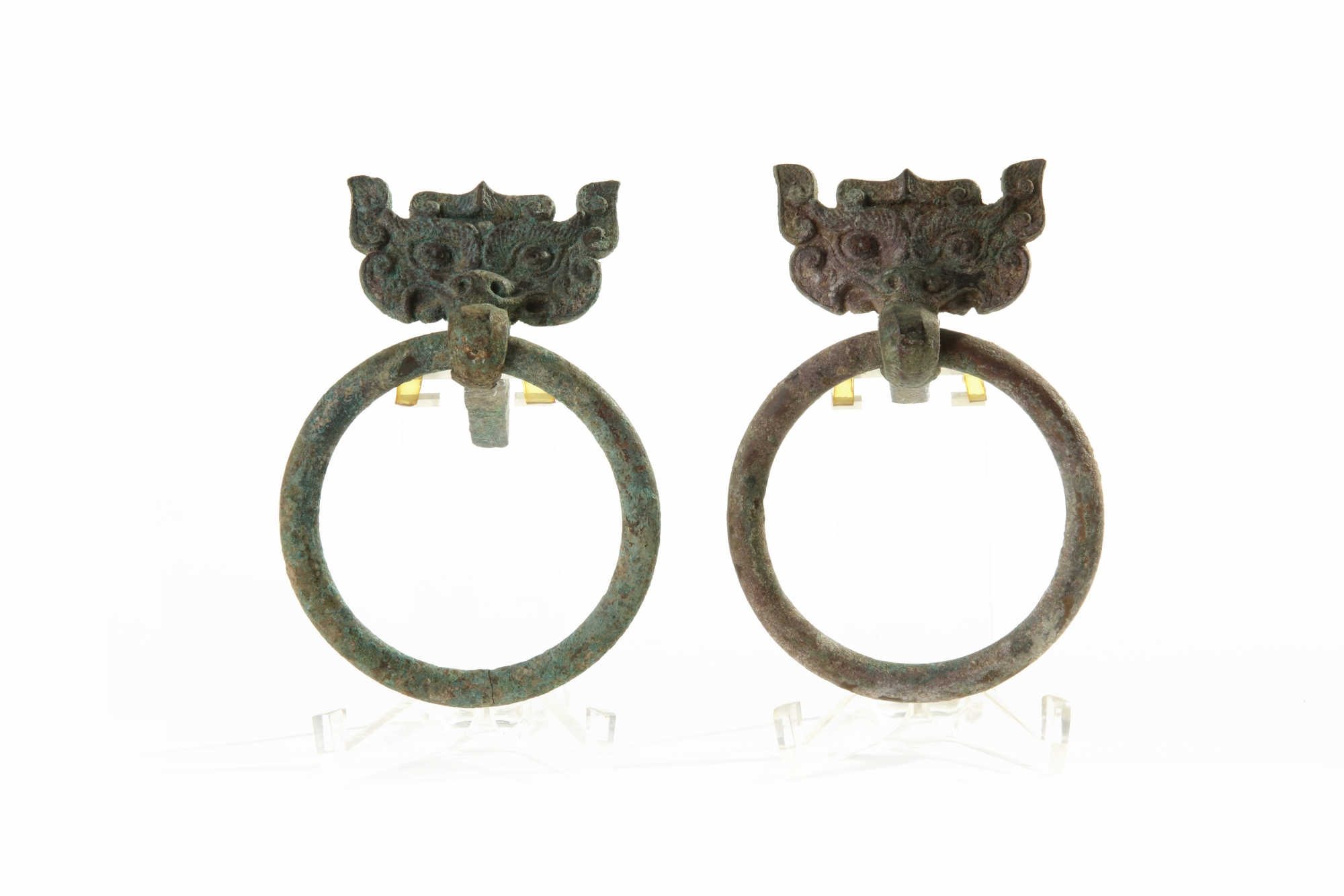 A pair of Chinese bronze taotie mask fittings with loose-ring handles