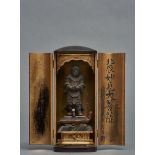 A small Japanese black lacquered zushi-shrine holding at the gilded inside a wooden figure