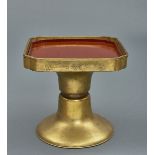 A Japanese square brass stand on a round diabolo shaped base