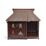 A Japanese wooden stand for tea utensils in the shape of a thatched tea house