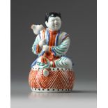 A Japanese figure of a boy on a drum