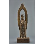 A large Japanese wooden standing Buddha with a mandorla