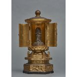 A small Japanese round gold-leaf lacquered zushi-shrine on a hexagonal stand