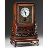 A Chinese gilt bronze table clock in a hongmu case and stand