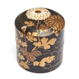 A Japanese black lacquered round tea caddy (natsume) decorated with chrysanthemum flowers