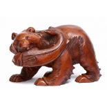 A large and heavy Japanese wood carving of a bear with a koi fish in its mouth.