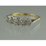 AN 18CT GOLD FIVE STONE DIAMOND RING. Of five old cut diamonds in illusion setting.