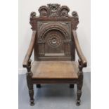 VICTORIAN OAK CARVED WAINSCOT TYPE ELBOW CHAIR with scrolled floral cresting and arch panelled back,