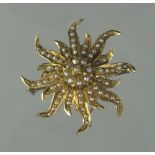 YELLOW METAL SUNBURST BROOCH set all over with seed pearls with hinged pendant bail.