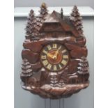 LATE 19TH CENTURY BAVARIAN CARVED AND STAINED WOODEN AUTOMATON CUCKOO CLOCK the case in the form of