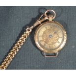 A GOLD FOB WATCH with engraved gold face with black Roman numerals and hands.