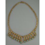 UNMARKED YELLOW METAL FRINGE NECKLACE. Graduated gold loops each set with a cabochon turquoise.