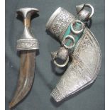 AN OMANI ARAB JABIYA DAGGER, having foliate engraved silver and yellow metal mounted handle,