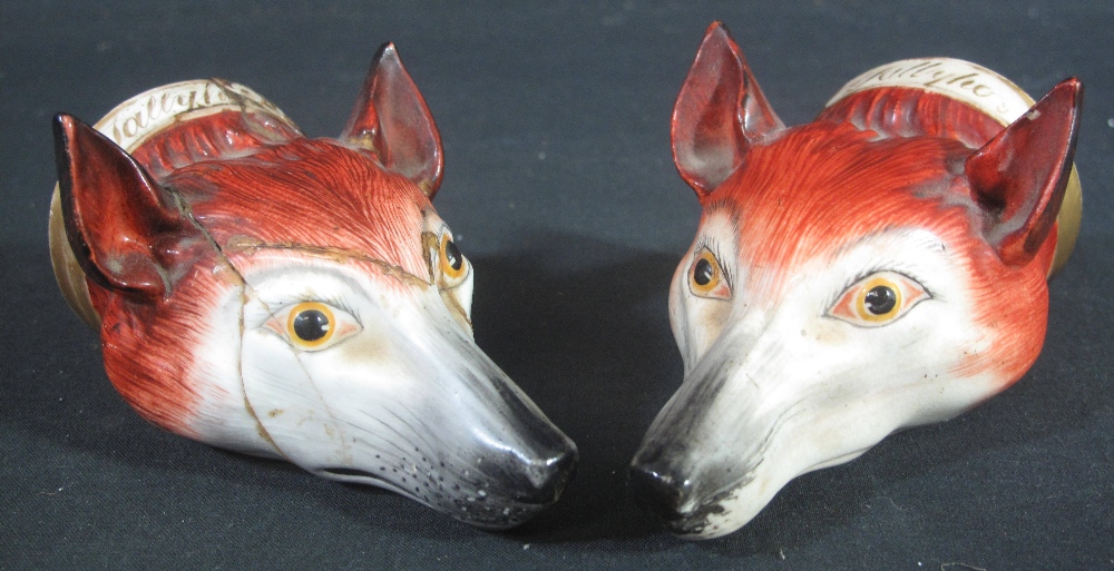A PAIR OF ENGLISH PORCELAIN FOX HEAD STIRRUP CUPS, realistically modelled and painted,