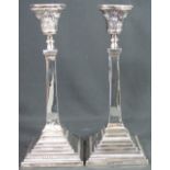 PAIR OF SILVER CLASSICAL DESIGN CANDLESTICKS having floral repousse decoration, waisted column,