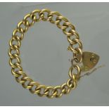 HEAVY 9CT GOLD CURB LINK BRACELET with heart shaped padlock clasp and safety chain.