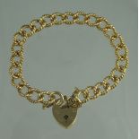 A 9CT GOLD ROPE TWIST CURB LINK CHARM BRACELET with heart shaped padlock clasp.