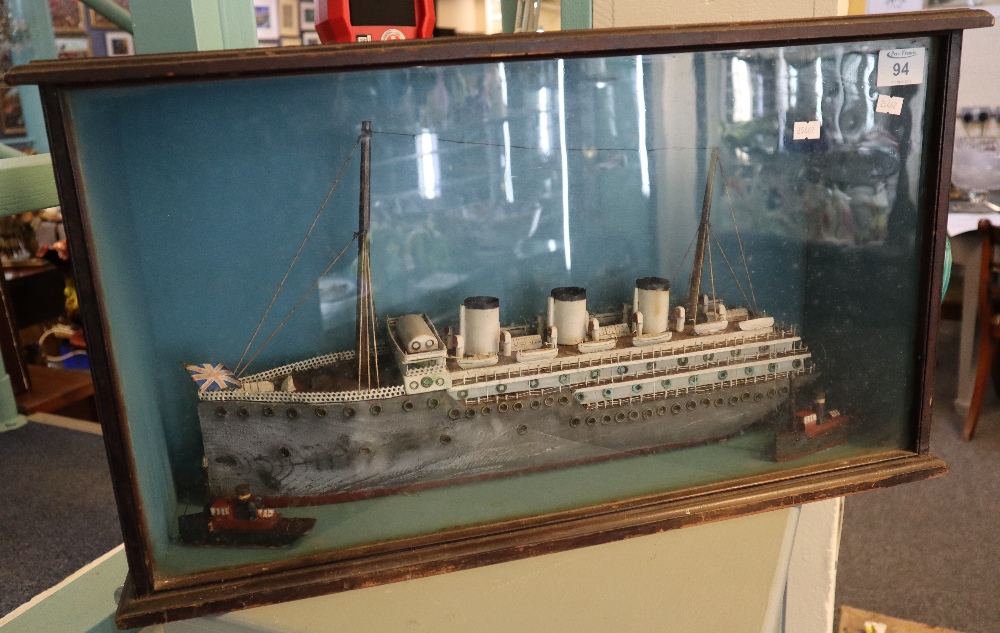 Mid 20th Century naive wooden scratch built model of a three funnel liner with two tugs.