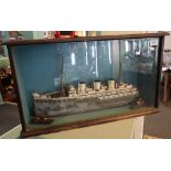 Mid 20th Century naive wooden scratch built model of a three funnel liner with two tugs.