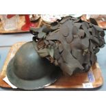 British post war helmet with camouflage, together with a British World War Two helmet. (2) (B.P.