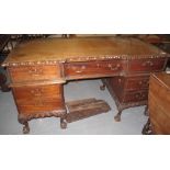 Reproduction hardwood partners desk with carved decoration standing on cabriole legs and ball and