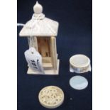 Small simulated ivory or bone shrine having two doors revealing figure to the interior and overall
