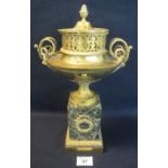 Yellow metal classical design two handled lidded urn on marble pedestal base. 33cm high approx. (B.