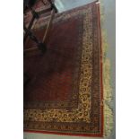 Persian design red ground machine made carpet with boteh devices to the field. (B.P. 24% incl.